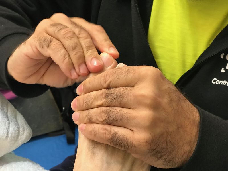 Manos trabajando un pie en una sesión de Sokushin-Do